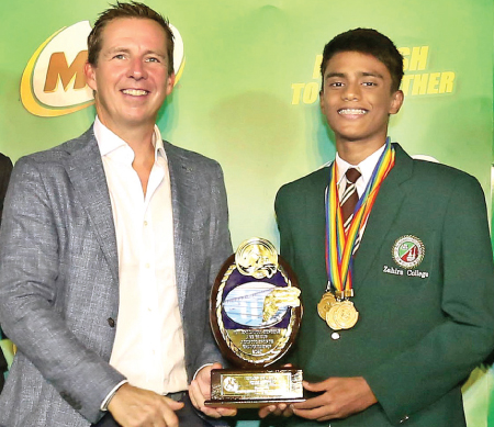 Muhammad, Under-16 Boys Champion of the 48th MILO Sri Lanka Schools’ Aquatic Sports Championships, proudly accepts his Championship Trophy from  Nestle Lanka PLC Managing Director Bernhard Stefan.     