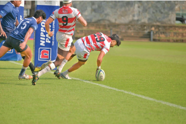 Mohamed Abzal (29) of CH & FC scores a try while his team mate Harsha Maduranga backs up.  