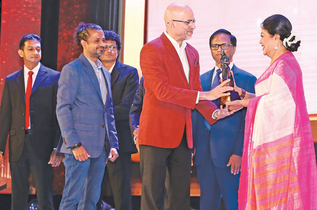 Mohammed Adamaly Producer of Dekala Purudu Kenek receiving the award for the Best Film 2019 from Chief Guest veteran actress Malani Fonseka. Director of the film Malith Hegoda looks on.