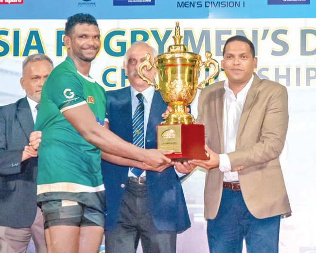 Proud Moment: Sri Lanka’s rugby captain, Suhiru Anthony, receives the Asian Division one Rugby Championship Trophy from Chief Guest Sports and Youth Affairs, Tourism and Lands Minister Harin Fernando.     